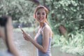 A smiling young Asian woman is listening to music on her mobile phone, wearing head phone Royalty Free Stock Photo