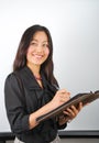Smiling young Asian woman making notes Royalty Free Stock Photo