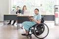 Smiling young Asian woman office worker in wheelchair holding tablet look at camera, disabled people working with colleague Royalty Free Stock Photo