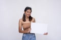 A smiling young Asian woman in pigtails smiling pleasantly while holding a white blank placard. Isolated on a white background Royalty Free Stock Photo