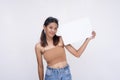 A smiling young Asian woman in pigtails smiling pleasantly while holding a white blank placard. Isolated on a white background Royalty Free Stock Photo