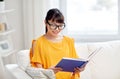 Smiling young asian woman reading book at home Royalty Free Stock Photo