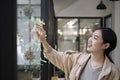 Young asian woman reading sticky notes on glass wall in creative office. Royalty Free Stock Photo