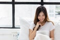 Smiling young asian woman use tablet computer and scrolling through tablet on bed at bedroom with happiness Pretty girl always