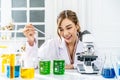 Smiling young asian woman wearing scientist uniform working at scientist laboratory with measuring liquid at laboratory Royalty Free Stock Photo