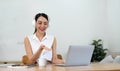 Smiling young asian woman working on laptop at home. Attractive asia female using computer remote studying, watching Royalty Free Stock Photo
