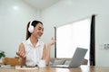 Smiling young asian woman working on laptop at home. Attractive asia female using computer remote studying, watching Royalty Free Stock Photo