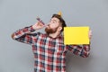 Smiling young bearded birthday man holding copyspace board