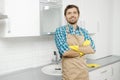 Smiling Young Bearded Brunet in Household Gauntlets and Apron