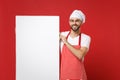 Smiling young bearded chef cook or baker man in striped apron white t-shirt toque chefs hat isolated on red background Royalty Free Stock Photo