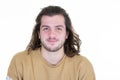 Smiling young bearded long haired man in brown sweater posing isolated on white wall background in studio portrait