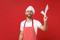 Smiling young bearded male chef cook or baker man in striped apron white t-shirt toque chefs hat isolated on red Royalty Free Stock Photo