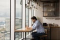 Smiling young man relaxing near big panoramic window using smartphone Royalty Free Stock Photo