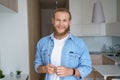 Smiling young man first time estate owner hold key to new home look at camera.