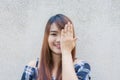 Smiling young beautiful asian woman closing her eyes with hands on concrete wall background. Royalty Free Stock Photo