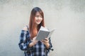 Smiling young beautiful asian women with book. Closeup brown head beautiful young woman pretty happy reading on concrete wall back Royalty Free Stock Photo