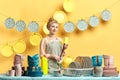 Smiling young beautiful housewife in gray apron holding sponge