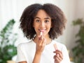 Smiling young beautiful lady holding nude color lipstick and get ready in morning Royalty Free Stock Photo