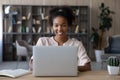 Smiling young biracial woman work online on laptop