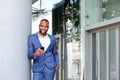 Smiling young black businessman with a cellphone outdoors in the city Royalty Free Stock Photo