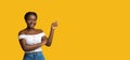 Smiling Young Black Lady Pointing Finger At Copy Space On Yellow Background Royalty Free Stock Photo