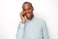 Smiling young black man against white background talking with mobile phone Royalty Free Stock Photo