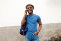 Smiling young black man with backpack talking on cellphone Royalty Free Stock Photo