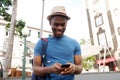 Smiling young black man looking at cellphone outdoors in city Royalty Free Stock Photo