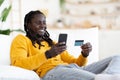 Smiling Young Black Man Making Online Shopping With Smartphone And Credit Card Royalty Free Stock Photo