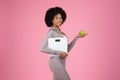 Healthy lifestyle concept with black woman holding scale and apple Royalty Free Stock Photo