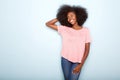 Smiling young black woman with hand in hair against blue background Royalty Free Stock Photo