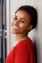 Smiling young black woman leaning against wall Royalty Free Stock Photo