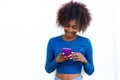 Smiling young black woman looking at mobile phone Royalty Free Stock Photo