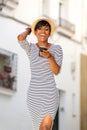 Smiling young black woman reading text message on cell phone Royalty Free Stock Photo