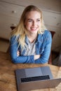 Smiling young blond woman with laptop and looking up Royalty Free Stock Photo