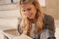 Smiling young blonde casual woman reading book Royalty Free Stock Photo