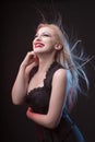 Smiling young blonde woman in corset with hair in motion Royalty Free Stock Photo