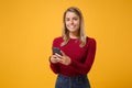 Smiling young blonde woman girl in casual clothes posing isolated on yellow orange wall background studio portrait Royalty Free Stock Photo