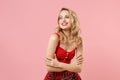 Smiling young blonde woman girl in red sexy clothes posing isolated on pastel pink wall background studio portrait Royalty Free Stock Photo