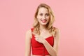 Smiling young blonde woman girl in red sexy clothes posing isolated on pastel pink wall background studio portrait Royalty Free Stock Photo