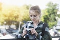 Smiling young blonde woman holding old retro film camera and taking pictures, copy space, amateur photographer, sunny summer Royalty Free Stock Photo