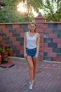 Smiling young blondie teenage posing in yard of her residence