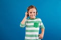 Smiling young boy listening music by headphone Royalty Free Stock Photo