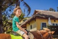 Smiling, young boy ride a pony horse. Horseback riding in a tropical garden Royalty Free Stock Photo