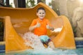 Smiling Young boy riding down a water slide showing a thumbs up Royalty Free Stock Photo