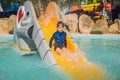 Smiling Young boy riding down a yellow water slide Royalty Free Stock Photo