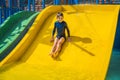 Smiling Young boy riding down a yellow water slide Royalty Free Stock Photo