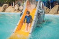 Smiling Young boy riding down a yellow water slide Royalty Free Stock Photo