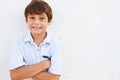 Smiling Young Boy Standing Outdoors Against White Wall Royalty Free Stock Photo
