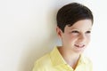 Smiling Young Boy Standing Outdoors Against White Wall Royalty Free Stock Photo